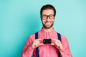 Sticker - Photo of young business man happy positive smile demonstrate bank plastic card isolated over teal color background