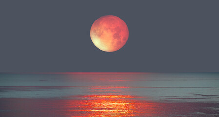 Wall Mural - Lunar eclipse over the sea at sunset 