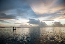 A Woman Fly Fishing From A Boat In The Florida Keys At Sunset
