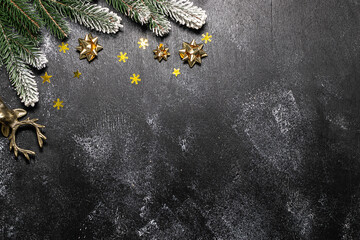 Wall Mural - Minimalism style Christmas composition with fir tree branches and golden decorations on black rustic background top view, copy space for your text.