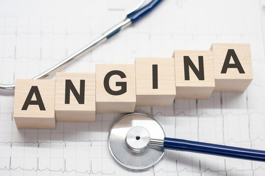 wooden block form the word angina with stethoscope on the doctor's desktop