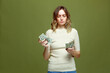 © Georgii - Financial problem. Frustrated young woman counting cash dollar banknotes need money for pay debt on green background