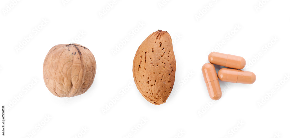 Nuts with pills on white background