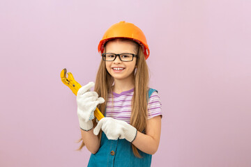 A little girl was going to do repairs in the house. A child with a protective helmet on his head.