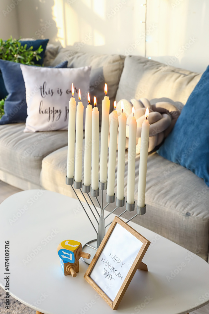 Menorah and dreidels in room decorated for Hanukkah celebration