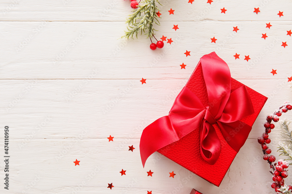 Beautiful composition with Christmas gift box and decor on white wooden background