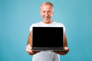 Poster - Happy mature man showing black empty laptop screen