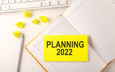 Poster - PLANNING 2022 text on sticker on the diary with keyboard and pencil