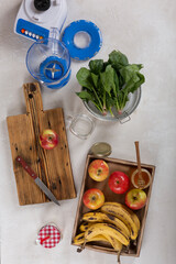 Wall Mural - Ingredients of fruit smoothie with spinach on the table close-up. Bananas, apples, spinach, honey