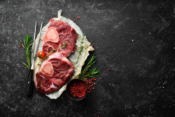 Osso buco Veal steak with rosemary and spices. On a black background. Top view.