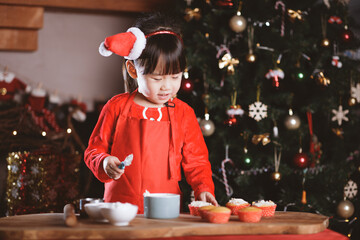 Wall Mural - young girl making Santa cupcake for Christmas party at home