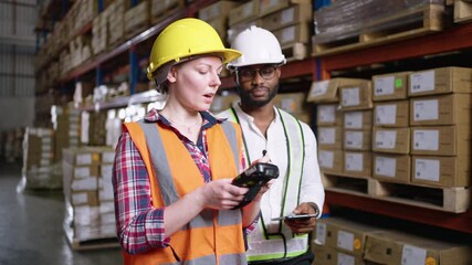 Wall Mural - Multi ethnic group of warehouse workers in discussion inspecting inventory in a large distribution center. concept of teamwork and occupation.