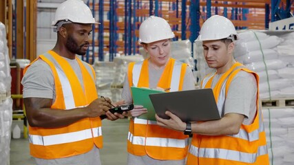 Wall Mural - Multi ethnic group of warehouse workers in discussion in a large distribution center. concept of teamwork and occupation.