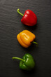 vegetable concept three different colors of bell peppers lying on the dark background
