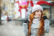 Glorious ginger lady walking at the city with snowflakes