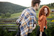 © alfa27 - Happy couple walking in countryside in the evening, redhead curly lady is in love cheerfully looking at boyfriend, summer time concept. side view portrait of man and woman in casual wear
