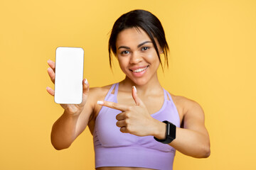 Aufkleber - Sports application. Excited black lady holding and showing smartphone, indicating at black empty screen for mockup