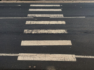 Pedestrian crossing marked on the road with black and white paint - Zebra crossing for people in busy road