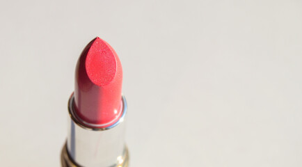 Close-up of pink lipstick on a white background, top view