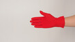 © nisara - Right Hand wearing red latex gloves on white background.