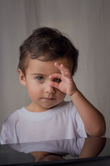 portrait of little boy in white shirt surprised expressing that everything is fine