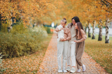 Wall Mural - Little girl with mom outdoors in park at autumn day