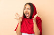 © luismolinero - Young Indian woman isolated on beige background with surprise facial expression