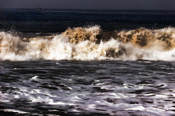 An artistic expression of a gloomy winter ocean and a white wave of rolling waves