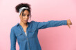 Young latin woman isolated on pink background showing thumb down with negative expression