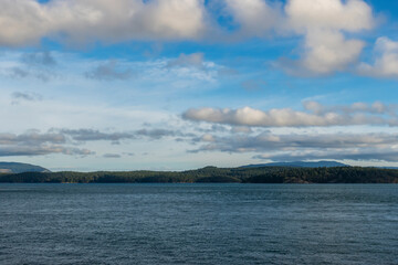 Wall Mural - View of a vibrant blue sky above the San Juan Islands from the Anacortes Ferry in Washington.