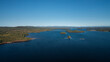 Green forest and lakeshore with islands at Lake Siljan from above with blue sky in Dalarna, clouds in sky, Sweden.