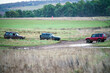 © Martin - three Land Rover Discovery 4x4 off-road vehicle driving across mud, water-logged terrain and wading through deep water pools, Wilts UK.