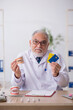 © Elnur - Old male doctor dentist working in the clinic
