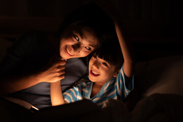 young Asian mother and little daughter girl on bed, cozy love sleepy at childhood home, at night