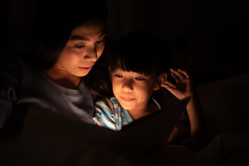 Wall Mural - young Asian mother and little daughter girl on bed, cozy love sleepy at childhood home, at night