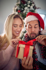 Wall Mural - Happy caucasian couple exchanging Christmas gifts