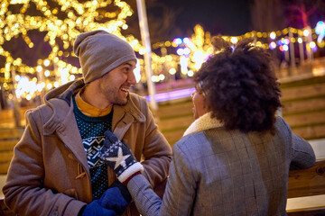 Wall Mural - Man and woman dating  at night Street Decorated With Winter Lights