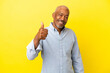 Leinwandbild Motiv Cuban Senior isolated on yellow background giving a thumbs up gesture