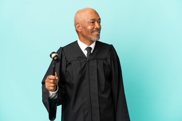 Wall Mural - Judge senior man isolated on blue background looking side