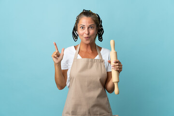 Wall Mural - Middle age woman in chef uniform intending to realizes the solution while lifting a finger up