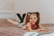 © Татьяна Добрикова - a cheerful girl is lying on the bed in the bedroom