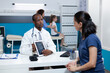 © DC Studio - African american pediatrician doctor holding tablet computer with girl radiography on screen explaining healthcare treatment to patient mother during appointment in hospital office. Medicine service