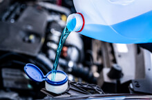 Pouring Antifreeze. Filling A Windshield Washer Tank With An Antifreeze In Winter Cold Weather...