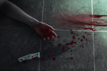 Big Sharp Kitchen Knife With Blood, Female Hand Of Victim And Bloody Traces. Weapon And Person Lies At On The Floor Lined With Green Tiles. Flat Lay. The Concept Of Murder And Crime