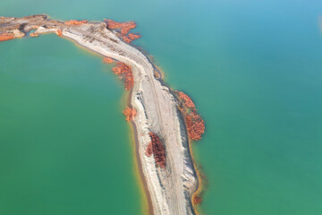 Quarry for mining and enrichment of titanium and other rare ores. Blue water in the enrichment tank.