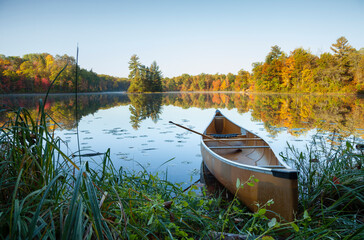 Wall Mural - canoe with paddle on shore of beautiful lake with island in northern minnesota at dawn