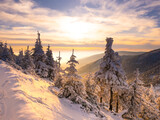 Fototapeta Na ścianę - Scenic snowy landscape with a view from a mounatin range to the valley, snow, sky,clouds,sky,sunlight.Spruce trees with rime, scenic landscape. Jeseniky.Czech republic. .