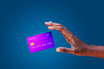 Close up african american female hand and levitating mockup bank credit card with online service on blue background