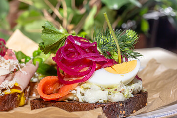 Wall Mural - Traditional Danish sandwich, Smerrebred with salted salmon, pickled onion, egg and salad on rye bread.