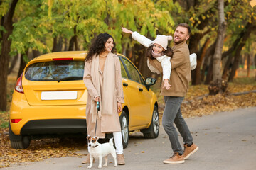 Wall Mural - Happy family with cute dog near yellow car in park on autumn day